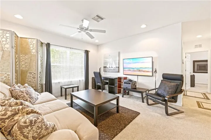 Loft with couch, coffee table, TV and desk with desk chair
