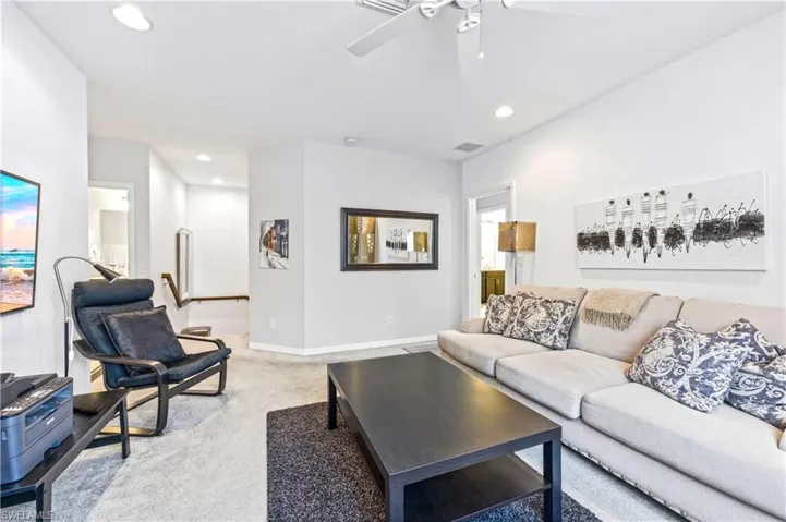 Loft with couch, coffee table, TV and desk with desk chair