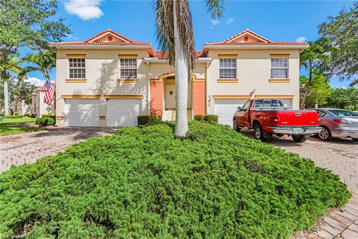 Mediterranean / spanish home with stucco siding, a tile roof, a garage, and decorative driveway