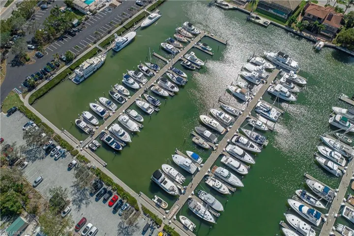 Aerial view of property and surrounding area with a large body of water and a marina