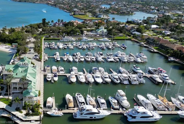 Aerial overview of property's location featuring a nearby body of water and a marina