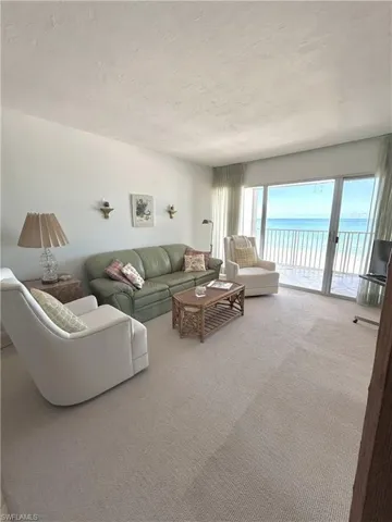 Living area featuring carpet floors and a textured ceiling