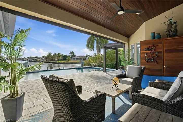 View of patio / terrace featuring outdoor lounge area, an outdoor pool, a water view, and ceiling fan