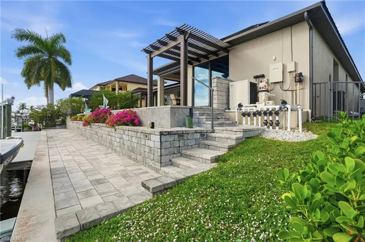Rear view of house featuring a patio, stucco siding, and a pergola