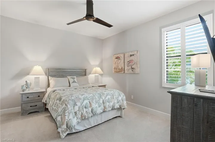 Bedroom featuring light colored carpet and a ceiling fan