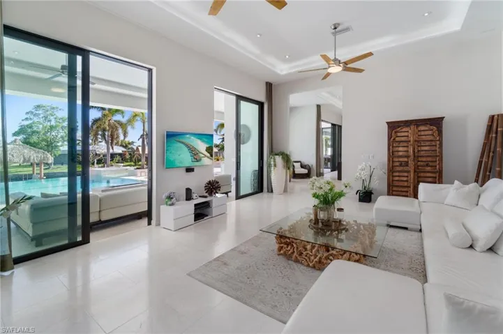 Living room featuring a tray ceiling and ceiling fan