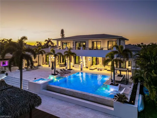 Pool at dusk with outdoor lounge area patio area, and an in ground hot tub