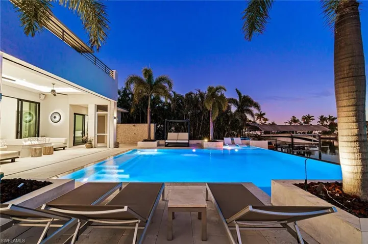 Pool at dusk with ceiling fan and a patio