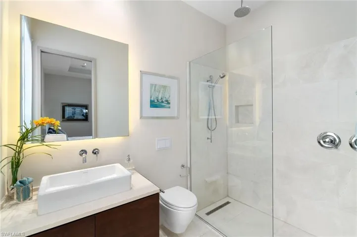Bathroom with vanity, toilet, and a tile shower
