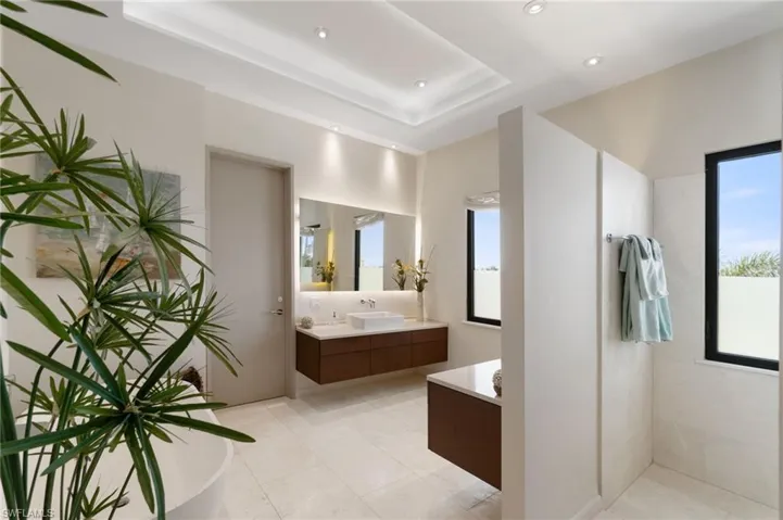 Bathroom with tile patterned floors, vanity, separate shower and tub, and a tray ceiling