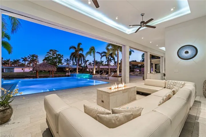 Pool at dusk with ceiling fan and pool water feature