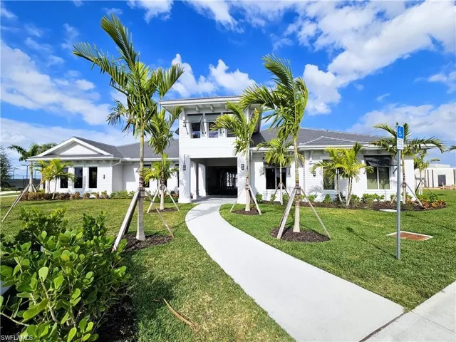 View of front facade with driveway, a carport, and a front lawn