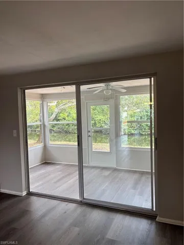 Doorway to outside 4 Season Sunroom with plenty of natural light, wood finished floors, a ceiling fan