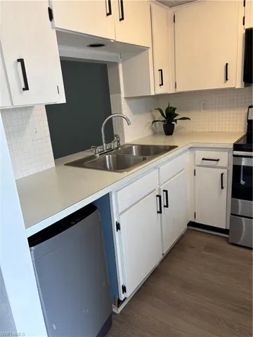 Kitchen featuring range, light countertops, dishwasher, and backsplash