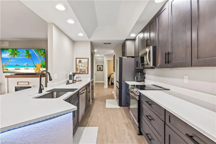 Beautifully updated kitchen with new stainless-steel appliances, ample cabinet space, and breakfast bar seating.