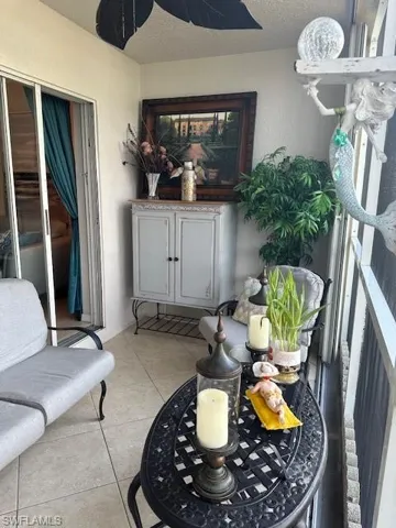 Patio with ceiling fan, light tile floors, and storage cabinet. Patio opens to common area with BBQ grill and picnic area adjacent to lake nearby.  Lakeview, and fountainviews from patio.