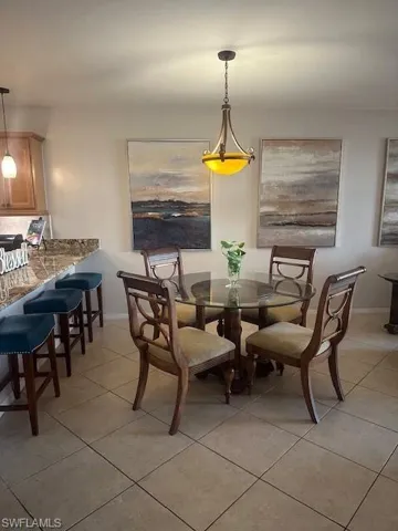 Open Dining area with tile and barstools at kitchen counter