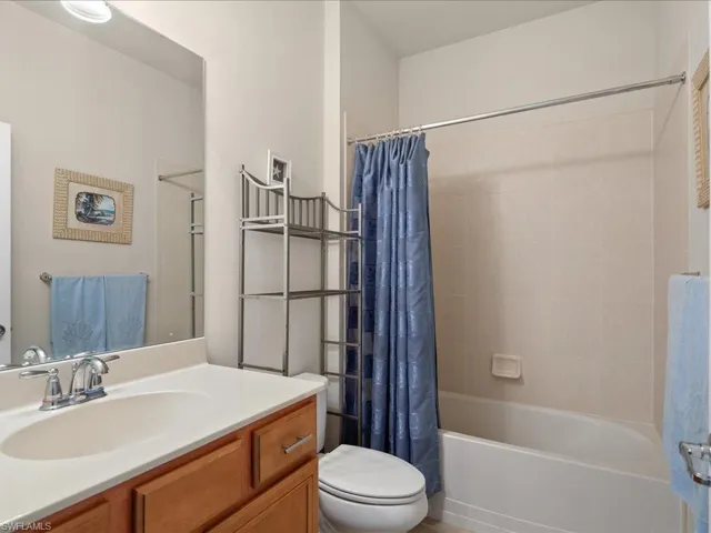 Full bathroom featuring shower / bath combo with shower curtain, vanity, and toilet