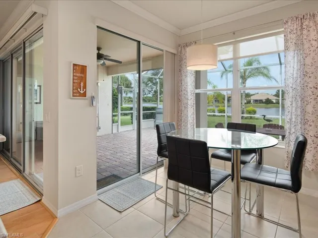 Dining space featuring ornamental molding, light wood-type flooring, a water view, and ceiling fan