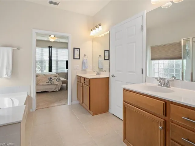 Bathroom with a healthy amount of sunlight, tile flooring, vanity, and ceiling fan