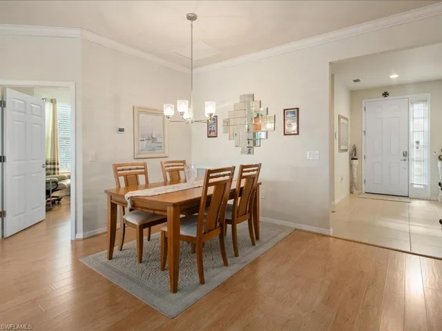 Dining space featuring a chandelier, light hardwood / wood-style flooring, and crown molding