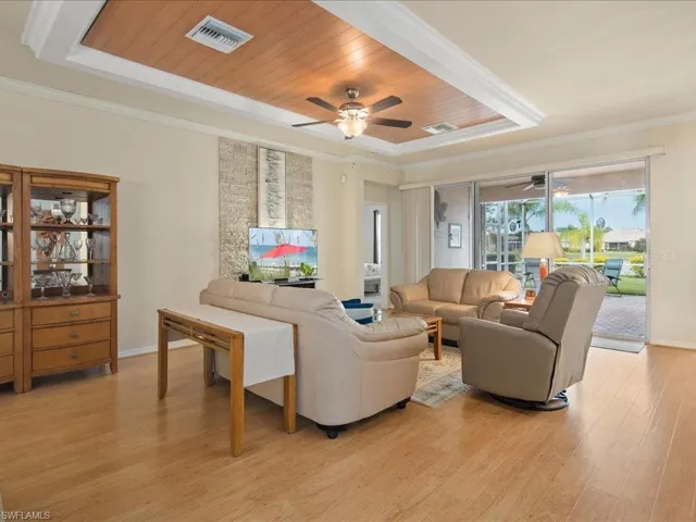 Living room featuring ceiling fan, light hardwood / wood-style flooring, crown molding, and wooden ceiling
