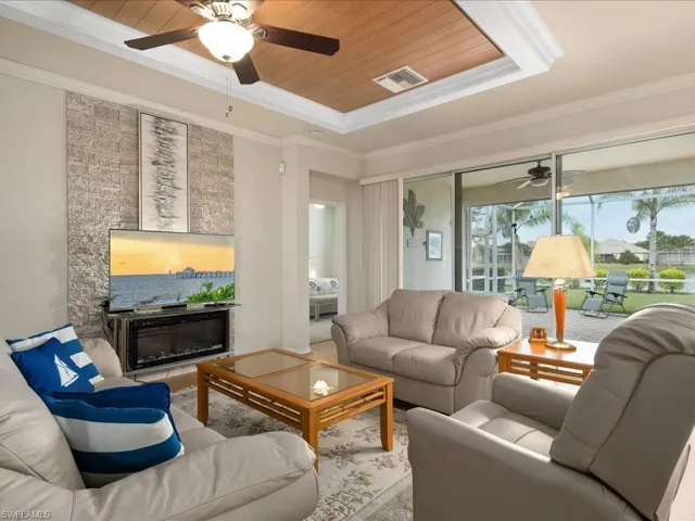 Living room with wood ceiling, ornamental molding, and ceiling fan
