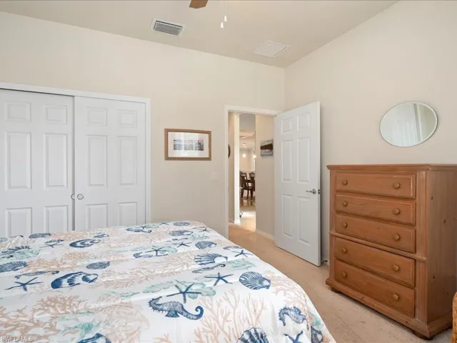 Bedroom with ceiling fan, light colored carpet