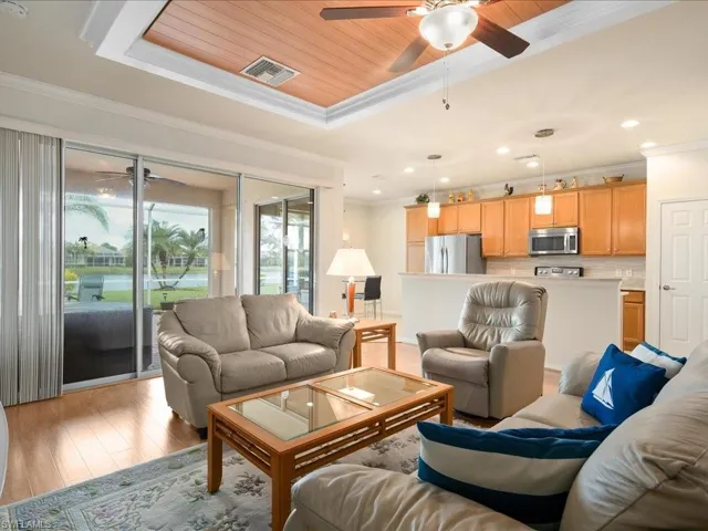 Living room featuring ceiling fan, light hardwood / wood-style flooring, crown molding, and wood ceiling