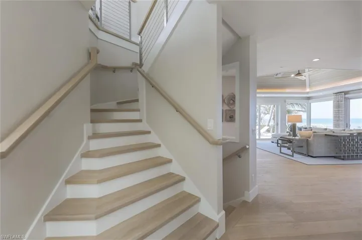 Stairs featuring hardwood / wood-style floors and a raised ceiling