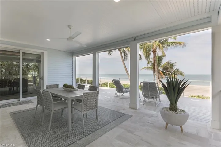 Sunroom with ceiling fan and a water view
