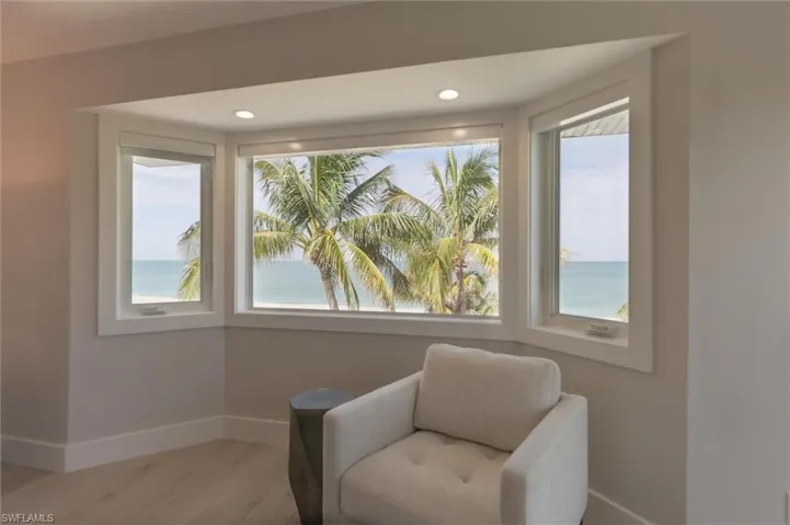 Sitting room featuring a wealth of natural light, a water view, and hardwood / wood-style floors