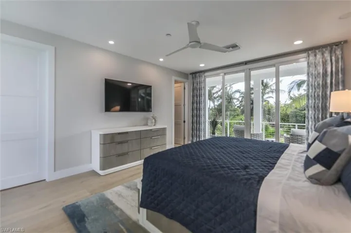 Bedroom with ceiling fan, light wood-type flooring, and access to outside