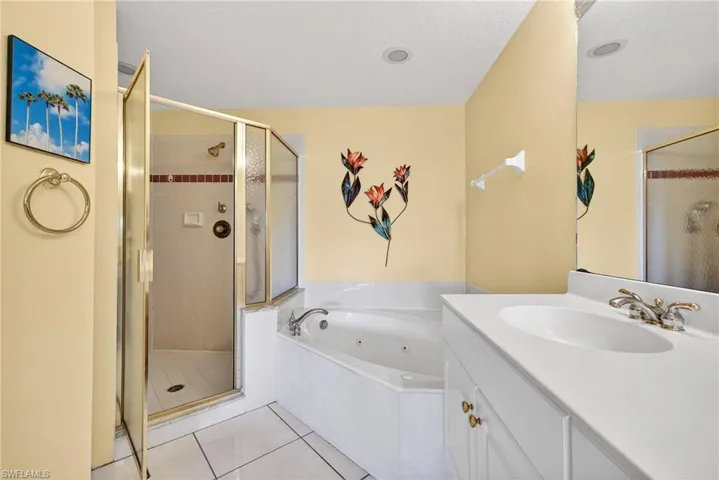 Full bath with a soaking tub, large shower, double vanity, and light tile patterned floors