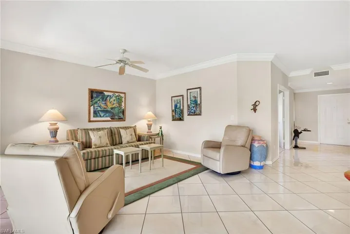 VIRTUALLY REFRESHED WITH A NEUTRAL PALETTE! Tiled living area with crown molding and ceiling fan