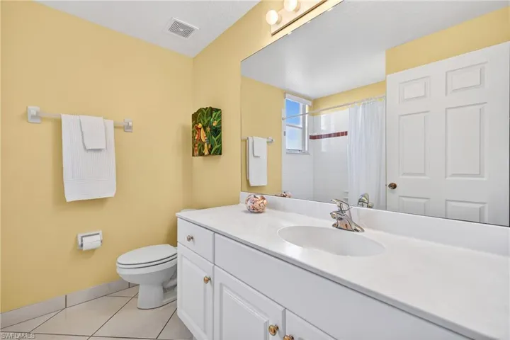 Full guest bath featuring new vanity, curtained shower, and white tile patterned flooring