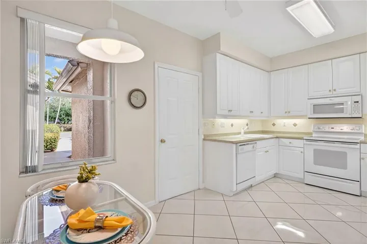 VIRTUALLY REFRESHED WITH A NEUTRAL PALETTE!  featuring white appliances, decorative light fixtures, white cabinetry, light countertops, and a ceiling fan
