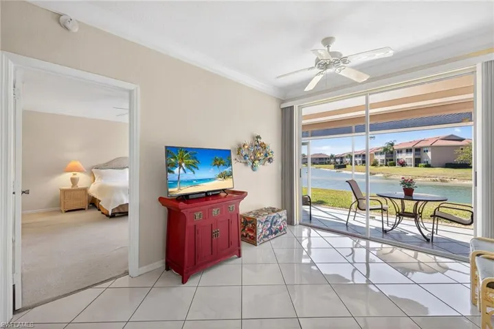 VIRTUALLY REFRESHED WITH A NEUTRAL PALETTE! room with crown molding, diagonal white ceramic tile flooring, ceiling fan, and double door sliders to the lanai