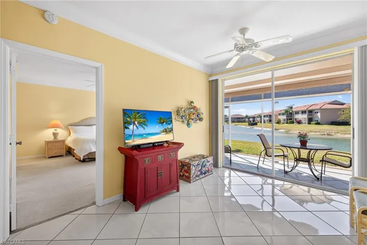 Great room with crown molding, diagonal white ceramic tile flooring, ceiling fan, and double door sliders to the lanai