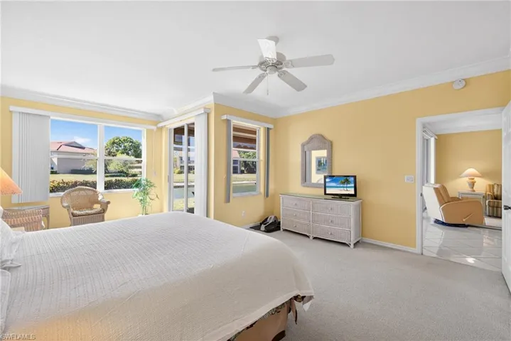 Master Bedroom featuring carpet, crown molding, ceiling fan, and sliding doors to exterior screened lanai
