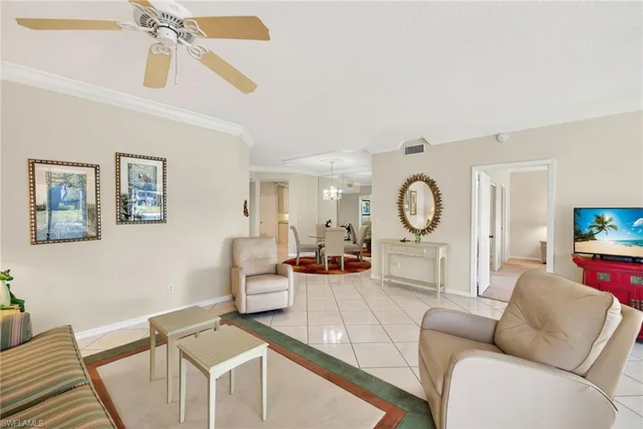 VIRTUALLY REFRESHED WITH A NEUTRAL PALETTE!  room with tile patterned flooring, ceiling fan, a chandelier, and crown molding
