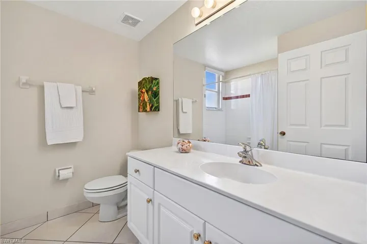 VIRTUALLY REFRESHED WITH A NEUTRAL PALETTE!  bathroom with curtained shower, vanity, and light tile patterned floors