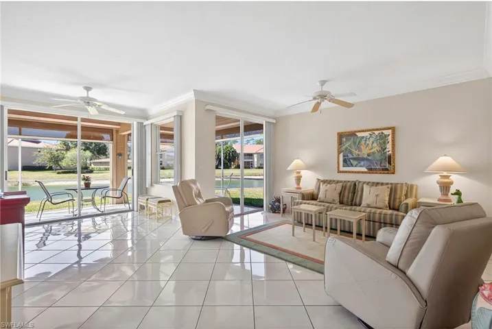 VIRTUALLY REFRESHED WITH A NEUTRAL PALETTE! Living room featuring ceiling fan, crown molding, and light tile patterned floors