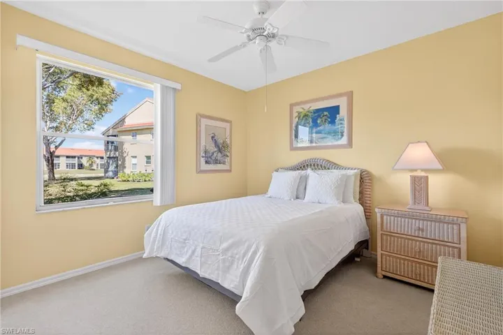 Carpeted guest bedroom featuring a ceiling fan and beautiful landscape views on large pie shaped lot location