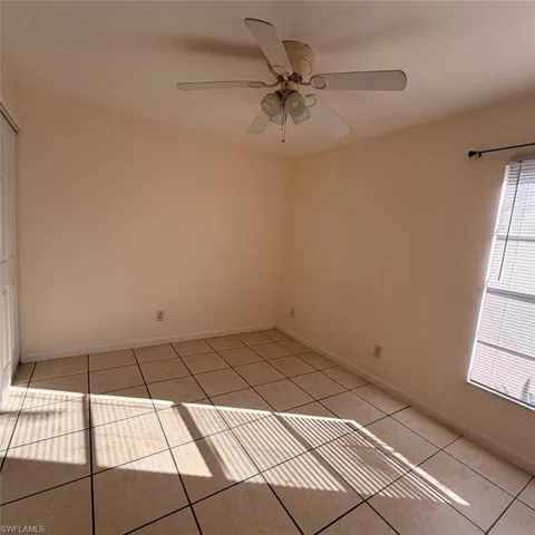Empty room featuring light tile patterned floors and ceiling fan