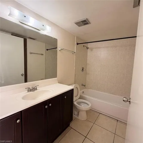 Full bathroom featuring vanity, washtub / shower combination, and light tile patterned floors