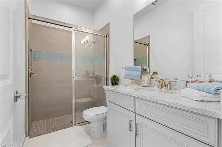 Full bathroom with vanity, a stall shower, and tile patterned flooring