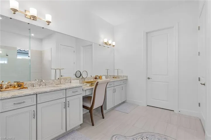 Full bathroom featuring double vanity and a tile shower