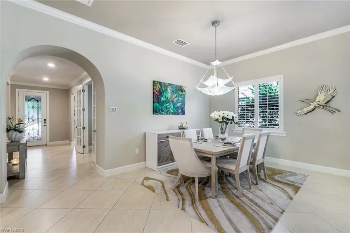 Tiled dining room featuring crown molding