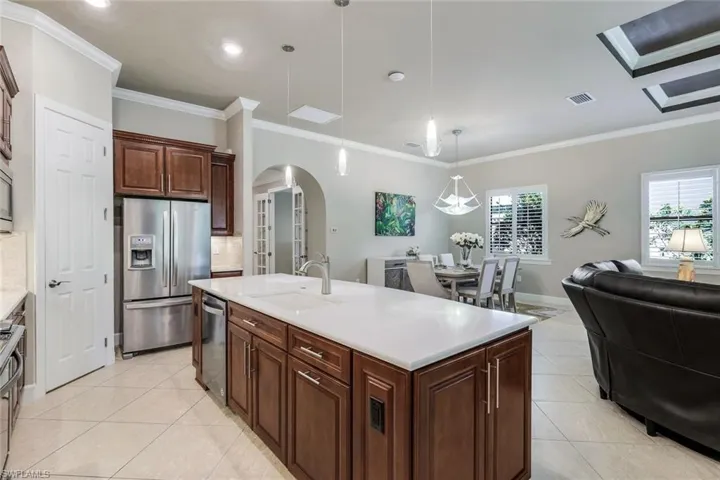 Kitchen featuring hanging light fixtures, a center island with sink, appliances with stainless steel finishes, sink.